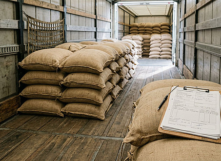 Kaffeesäcke auf Palette neben Transportpapieren als Symbol für Kaffeesteuer und Meldepflicht beim Transport durch Deutschland