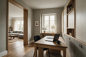 Kleines häusliches Arbeitszimmer mit Schreibtisch und Laptop in einem privaten Wohnumfeld.